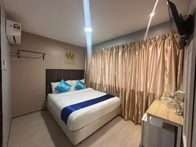 a bedroom with a large bed with blue pillows at SS GREY INN Jalan bukit bintang in Kuala Lumpur