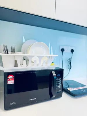 a black microwave sitting on top of a counter at XING LUN KLCC The Colony Infinitum in Kuala Lumpur