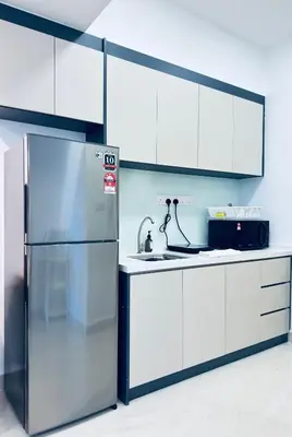 a stainless steel refrigerator in a kitchen with white cabinets at XING LUN KLCC The Colony Infinitum in Kuala Lumpur
