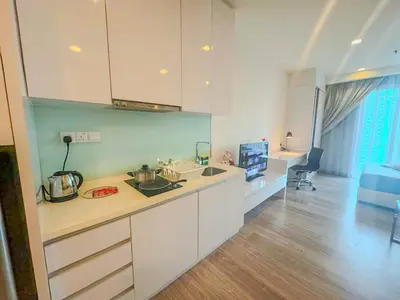 a kitchen with white cabinets and a counter top at One Ceylon Suites By OHaus in Kuala Lumpur