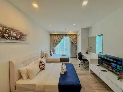 a large bedroom with a bed and a television in it at One Ceylon Suites By OHaus in Kuala Lumpur