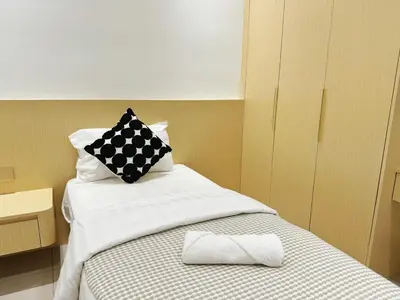 a bed with a black and white pillow on it at D3911 Klcc View Private Roof Terrace l 8Pax in Kuala Lumpur