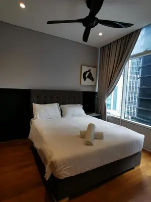 a bedroom with a large bed with a ceiling fan at Sky Suites KLCC by Deep Sleep in Kuala Lumpur