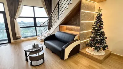 a living room with a christmas tree and a couch at 2BR 4PAX Stylish Duplex ARTE Mont Kiara in Kuala Lumpur
