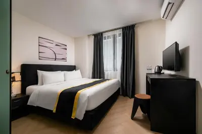 a hotel room with a bed and a flat screen tv at BRYQS Hotel KL Sentral in Kuala Lumpur