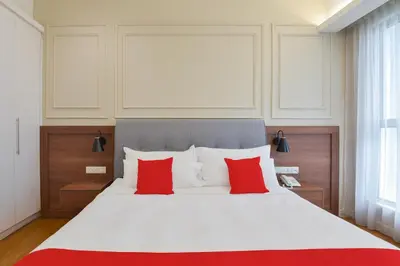 a bedroom with a large white bed with red pillows at Sunday Hotel Near Petronas Twin Tower Formerly Suasana Suites in Kuala Lumpur