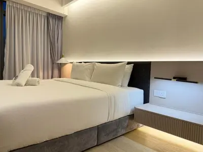 a hotel room with a large white bed and a tv at Eaton Residences KLCC By ARBAN in Kuala Lumpur