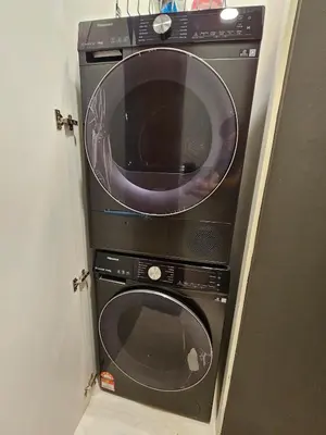 a microwave and a washing machine in a door at Sky Suites KLCC Level 58 in Kuala Lumpur