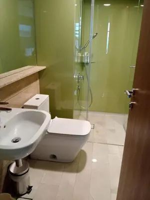 a bathroom with a toilet and a glass shower at Sky Suites KLCC Level 58 in Kuala Lumpur