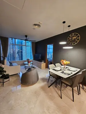 a living room with a table and chairs and a couch at Sky Suites KLCC Level 58 in Kuala Lumpur