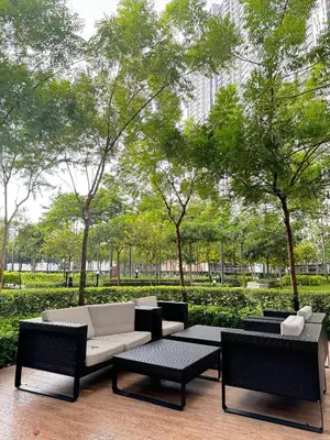 a patio with a couch and chairs and trees at RoomBnB MVertica in Kuala Lumpur
