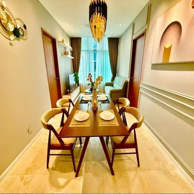 a dining room with a wooden table and chairs at Sky suites klcc by Elham in Kuala Lumpur