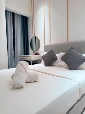 two beds in a hotel room with towels on them at Residensi Akson Bukit Bintang Axon nearby Pavilion TRX in Kuala Lumpur
