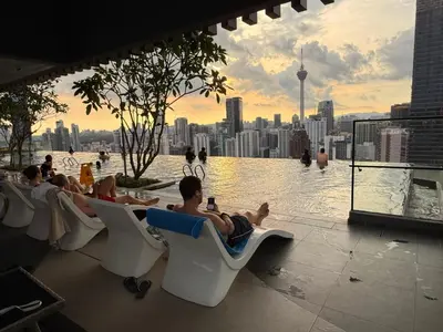 a group of people sitting in chairs on a rooftop pool at Residensi Akson Bukit Bintang Axon nearby Pavilion TRX in Kuala Lumpur