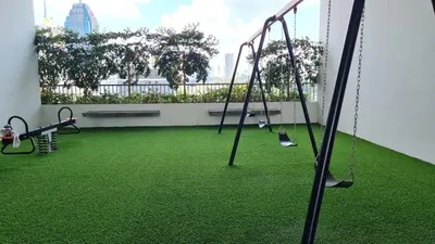 an empty playground with swings and green grass at Chambers Skypool KLCC in Kuala Lumpur