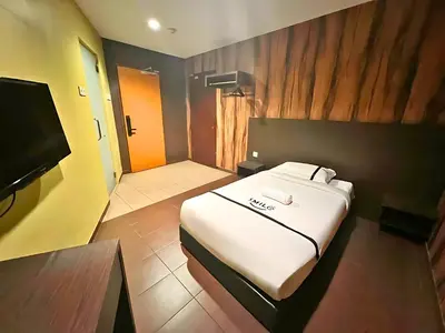 a bedroom with a bed and a flat screen tv at Seeds Hotel Cheras Permaisuri in Kuala Lumpur