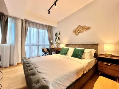 a bedroom with a large bed with green pillows at The Luxe by Infinitum Suites in Kuala Lumpur