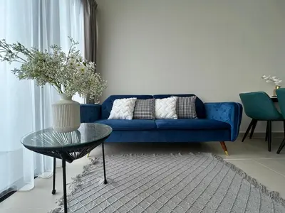 a blue couch in a living room with a table at The Luxe by Infinitum Suites in Kuala Lumpur