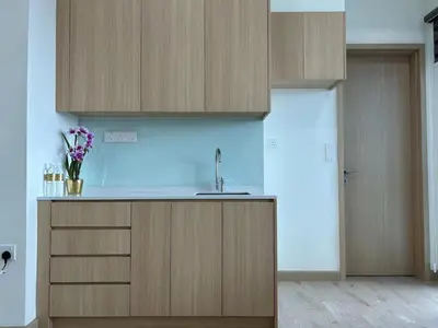 a kitchen with wooden cabinets and a sink at The Luxe by Infinitum Suites in Kuala Lumpur