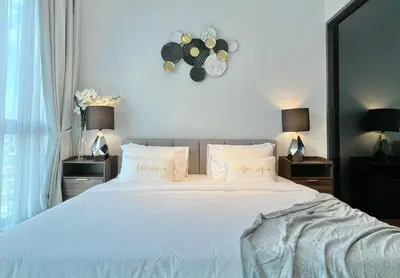 a bedroom with a large bed with a clock on the wall at The Luxe by Infinitum Suites in Kuala Lumpur