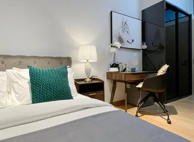 a bedroom with a bed with a desk and a chair at The Luxe by Infinitum Suites in Kuala Lumpur
