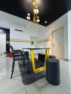 a dining room with a yellow table and black chairs at Comfy Arte Plus Ampang KL City 8 Pax-3BR-2CP in Kuala Lumpur