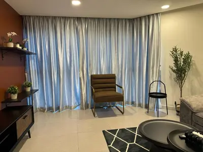 a living room with a chair in front of a large window at The Atrium at Jalan Ampang by OKBnB - Classy 3Bedroom Family Suite nearby KLCC , TRX and Pavilion KL in Kuala Lumpur