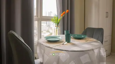 a table with two bowls and a vase with flowers on it at MayTower by Horizon Homes in Kuala Lumpur
