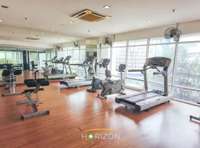 a gym with several treadmills and elliptical machines at MayTower by Horizon Homes in Kuala Lumpur
