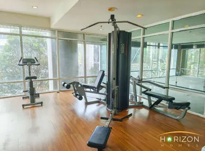 a gym with two tread machines in a room with windows at MayTower by Horizon Homes in Kuala Lumpur