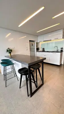 a large kitchen with a table and two stools at The Establishment Bangsar #23a by Ouki in Kuala Lumpur