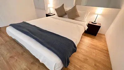 a bedroom with a large white bed with two lamps at The Establishment Bangsar #23a by Ouki in Kuala Lumpur