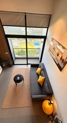 a living room with a couch and a large window at The Establishment Bangsar #2216 by Ouki in Kuala Lumpur