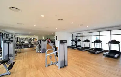 a gym with several treadmills and elliptical machines at The Establishment Bangsar #2216 by Ouki in Kuala Lumpur