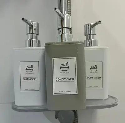 a group of three soap dispensers on a shelf at The Establishment Bangsar #2216 by Ouki in Kuala Lumpur