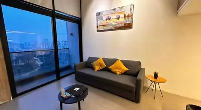 a living room with a couch and a large window at The Establishment Bangsar #2216 by Ouki in Kuala Lumpur
