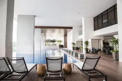 a lobby with a pool and three chairs at The Establishment Bangsar #29 by Ouki in Kuala Lumpur