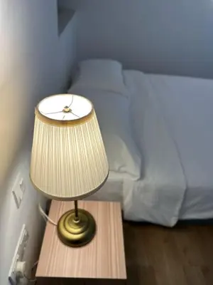 a lamp on a table next to a bed at The Establishment Bangsar #29 by Ouki in Kuala Lumpur
