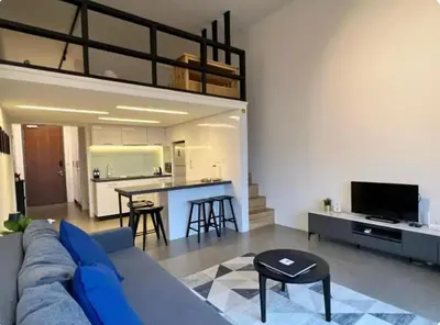a living room with a blue couch and a kitchen at The Establishment Bangsar #2222 by Ouki in Kuala Lumpur