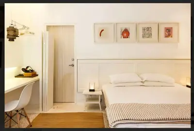 a white bedroom with a bed and a desk at M1- room w planter box in Kuala Lumpur