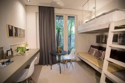 a room with a loft bed and a table and chairs at M1- room w planter box in Kuala Lumpur