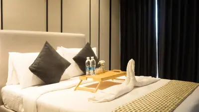 a white bed with a table on top of it at Axon Residences KLCC - Premium Suites in Kuala Lumpur