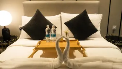 a bed with a table with two water bottles on it at Axon Residences KLCC - Premium Suites in Kuala Lumpur