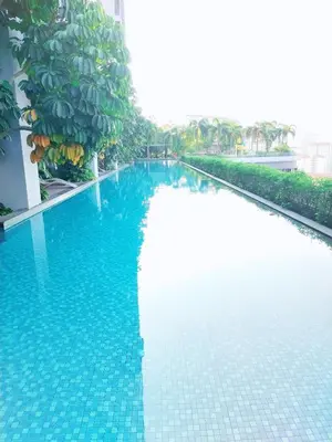 a blue swimming pool with a banana tree next to it at TRION Luxury City Suites Near KLCC & TRX in Kuala Lumpur