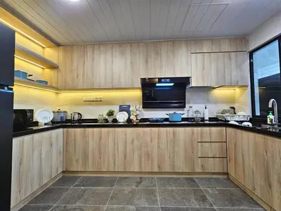 a kitchen with wooden cabinets and a black counter top at Fahrenheit 88 - Bukit Bintang in Kuala Lumpur