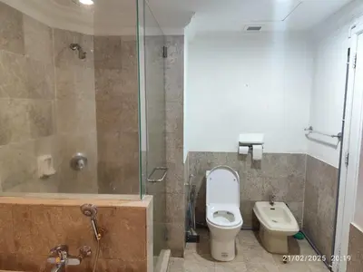 a bathroom with a toilet and a glass shower at The Marvelous Suites at Times Square Kuala Lumpur in Kuala Lumpur