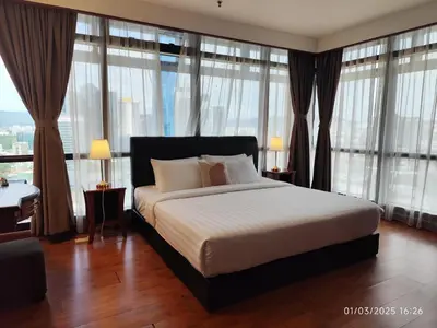 a bedroom with a large bed with large windows at The Marvelous Suites at Times Square Kuala Lumpur in Kuala Lumpur