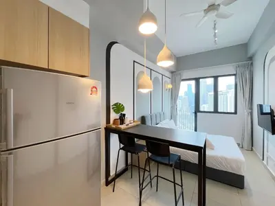 a kitchen with a refrigerator and a table and a bed at The Colony Infinitum By Couple Stay in Kuala Lumpur