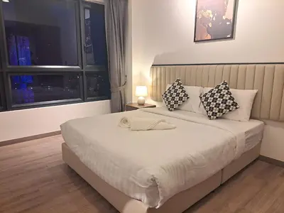 a bedroom with a large white bed with pillows and a window at Agile marigold Suite KL in Kuala Lumpur