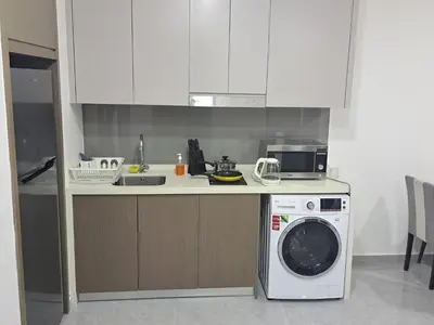 a kitchen with a washing machine and a microwave at Agile marigold Suite KL in Kuala Lumpur